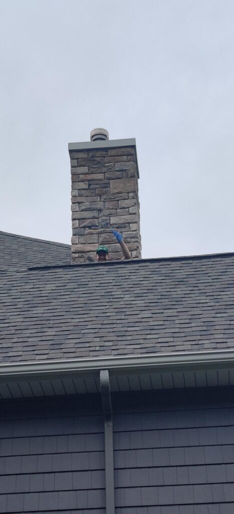 One of our technicians peaking over the rig of a house roof while providing 
 one of our pest control services. 