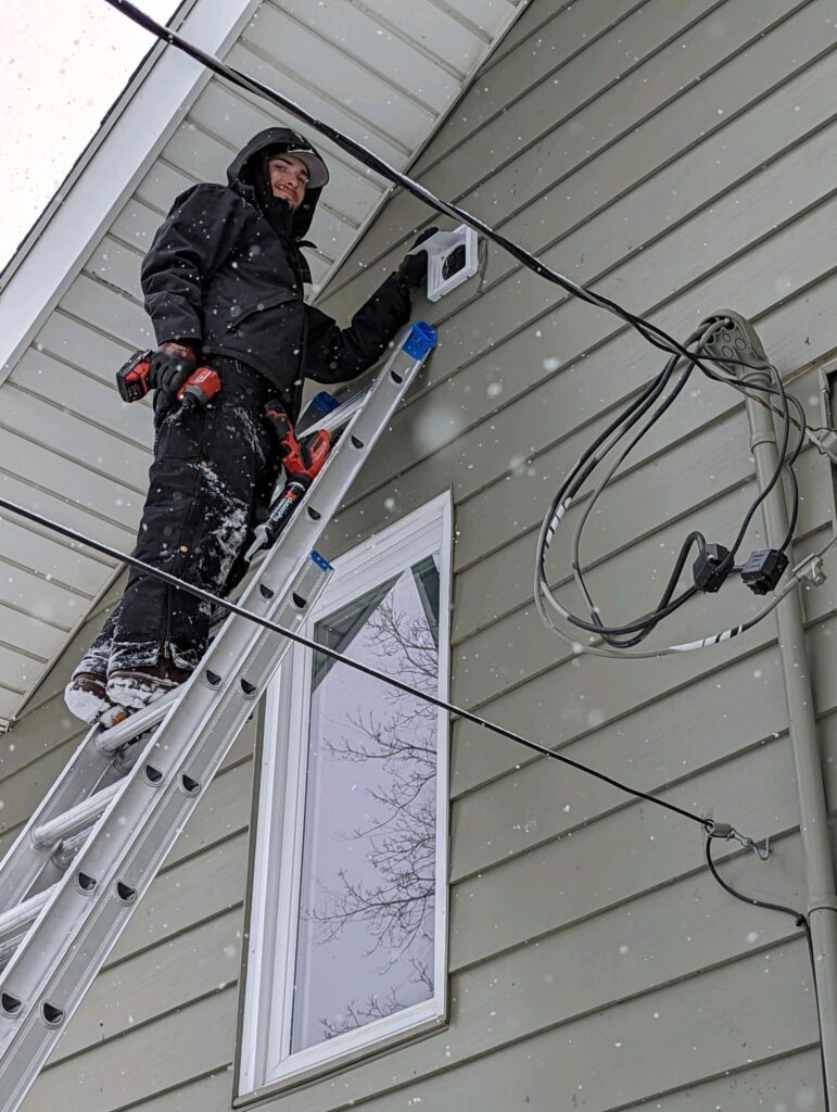 One of our technicians on a ladder securing a vent, representing one of our pest control services.