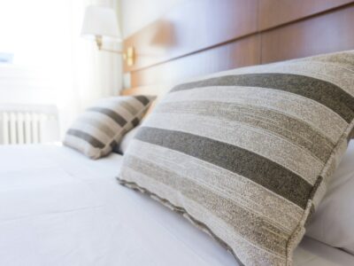 A close up view of pillows on a nicely made bed, representing peaceful feeling of being free from bed bugs.