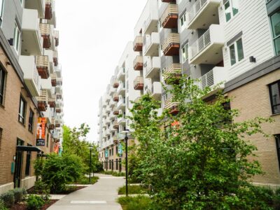 A courtyard pathway between two multistory condominium buildings, representing the type of location property mangers work to keep free of pests.