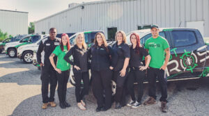 A group of our Pest Pros staff, posing in front of a line of our Pest Pros vehicles.